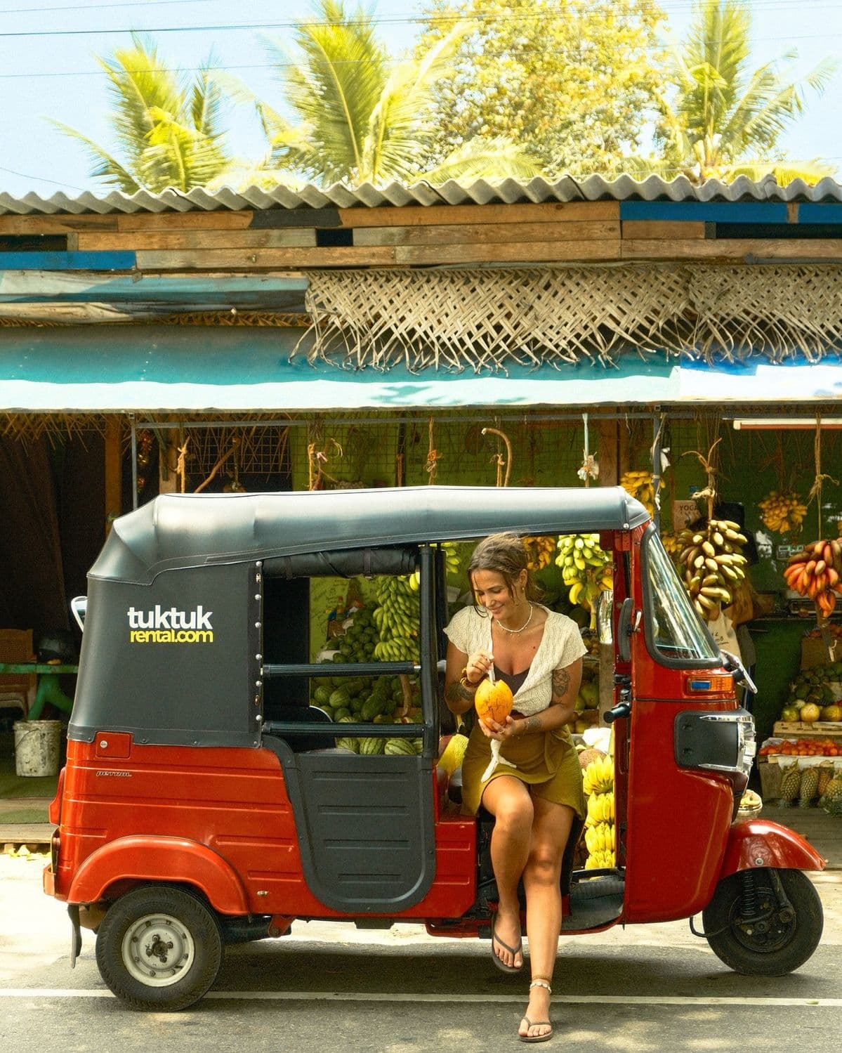 WeRent Tuk-Tuk Transfers in Watamu Guest stepping out of a WeRent tuk-tuk beside a fruit stall in Watamu